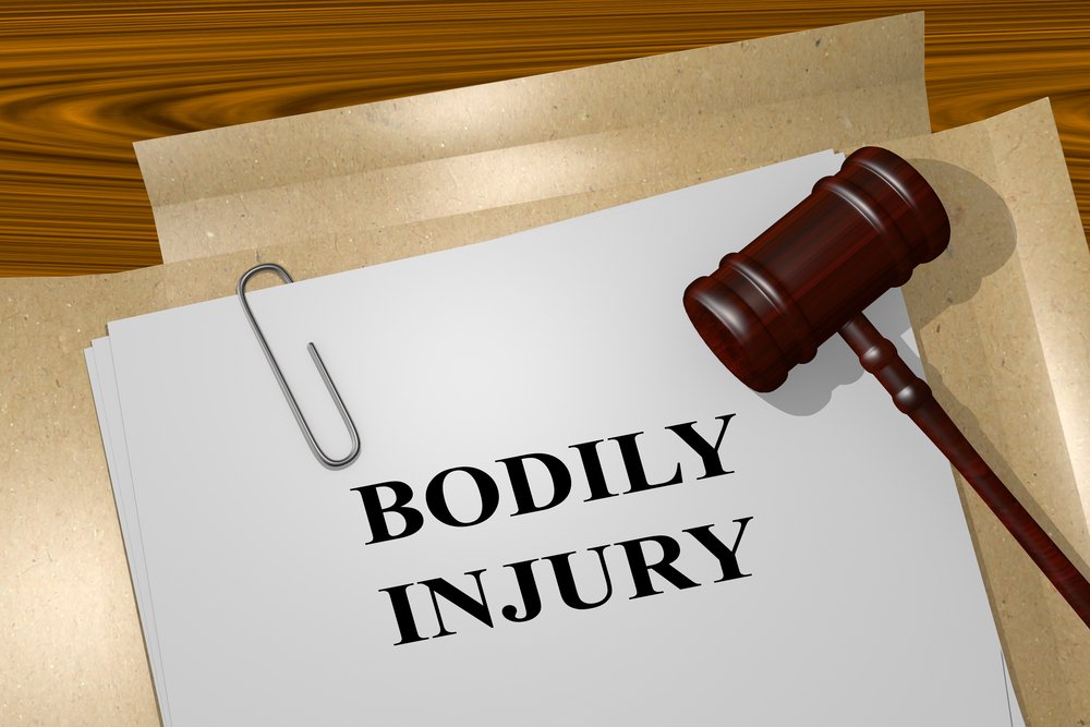 Gavel resting on a legal document labeled “Bodily Injury,” representing how umbrella insurance covers additional liability beyond home and auto policies.