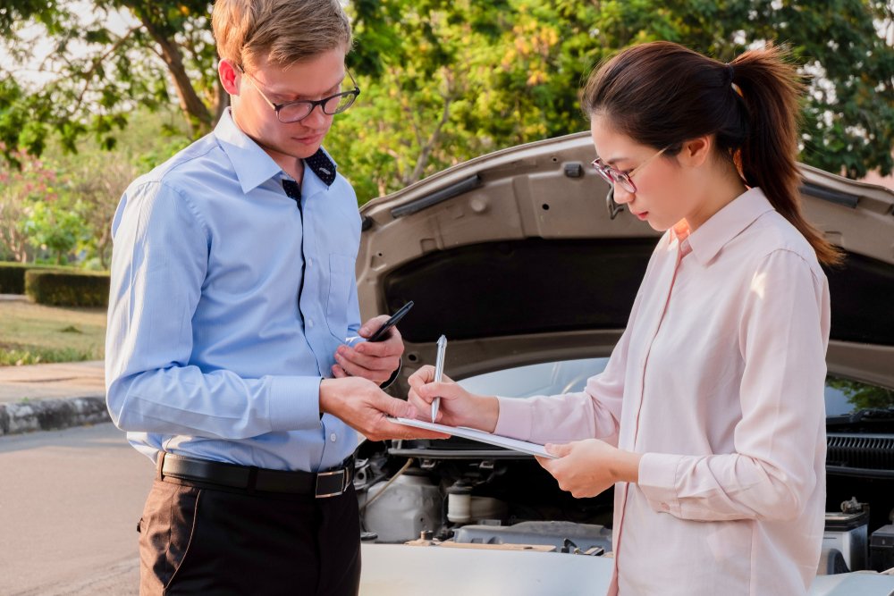 Insurance agent reviewing paperwork with driver after car accident, representing how umbrella insurance covers liability beyond auto policies.